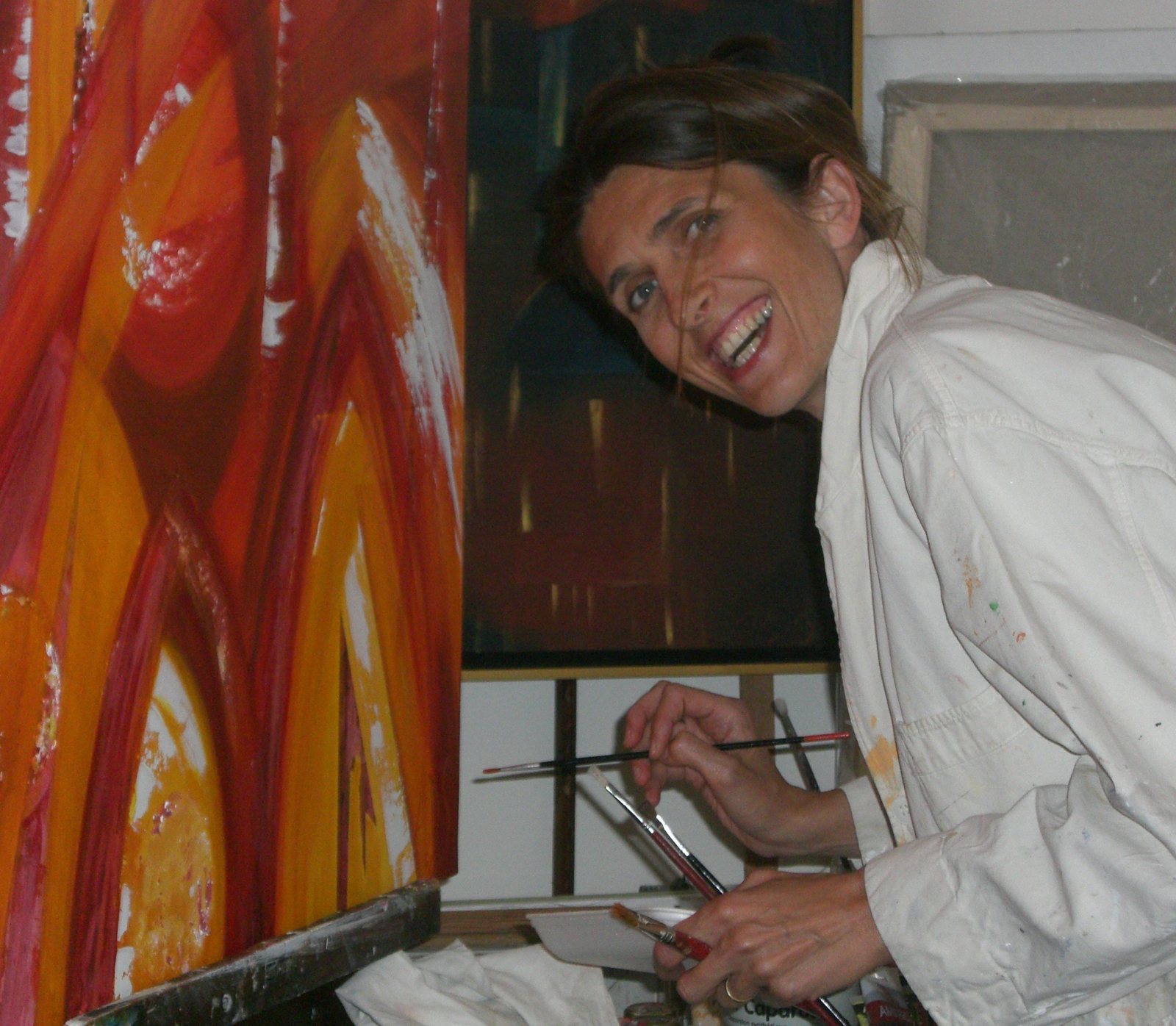 Agnès L-D Steeg souriante devant une de ses toiles